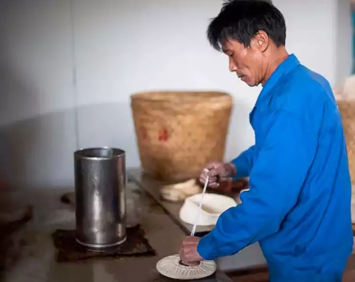 un ouvrier fabrique des gâteaux au thé blanc à la main un ouvrier fabrique des gâteaux au thé blanc à la main